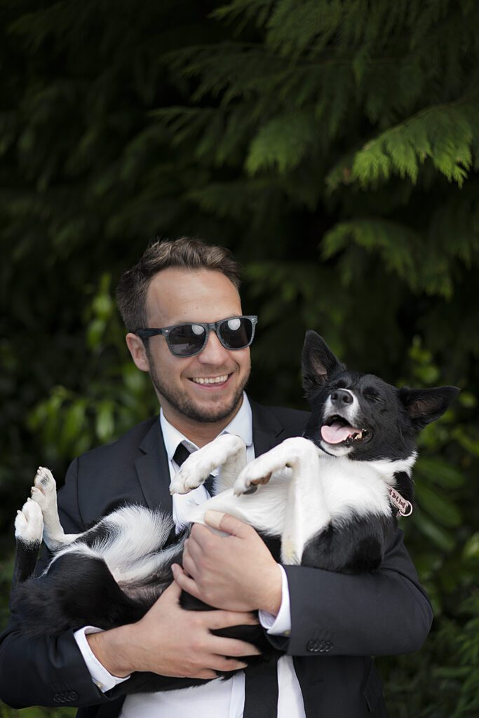 Jamie Sundance, Filmmaker Educator & Digital Artist in Aberdeen wearing a black suite holding his border collie "Lara"